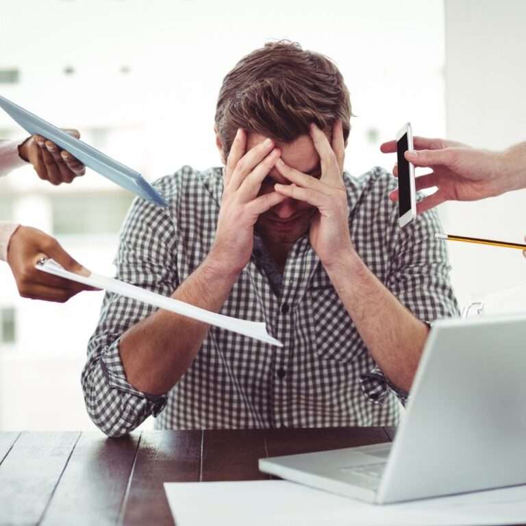Man overwhelmed by implementation management challenges and project overload, illustrating the need for change management